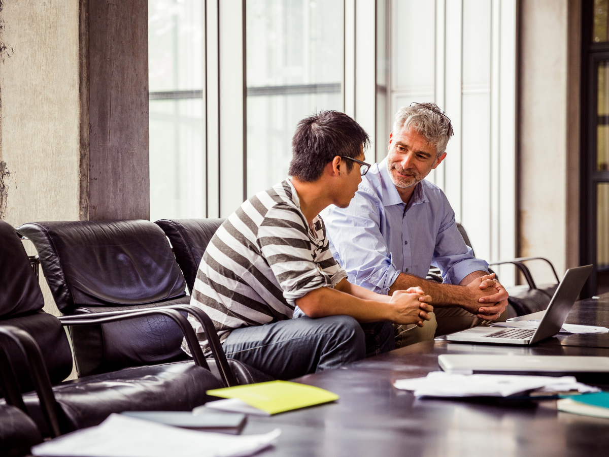 Two men seated talking